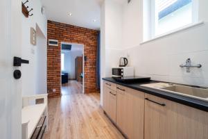 a kitchen with a sink and a brick wall at Apartamenty Weneckie in Zielona Góra
