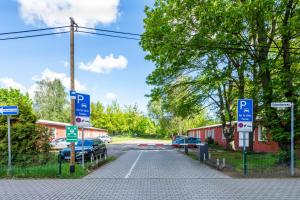 um parque de estacionamento com sinais de estacionamento na berma de uma estrada em Pension Schwalbenweg em Schönefeld