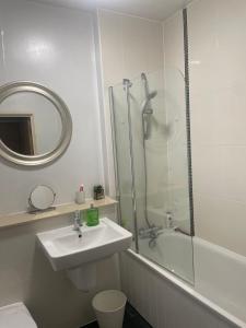 y baño con ducha, lavabo y espejo. en Apartment 7 en Milton Keynes