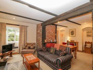 a living room with a couch and a tv at Field Cottage in Shepton Mallet