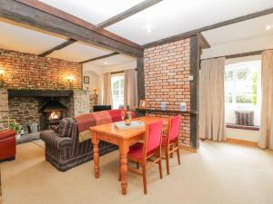 a living room with a table and a fireplace at Field Cottage in Shepton Mallet