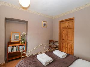 a bedroom with a bed and a book shelf at Field Cottage in Shepton Mallet