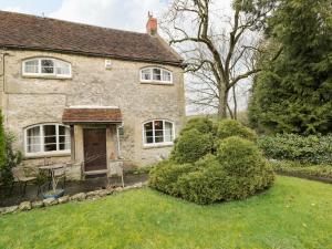 ein Steinhaus mit einem Tisch und Stühlen im Hof in der Unterkunft Field Cottage in Shepton Mallet