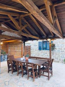 a wooden table and chairs on a patio at Almyra in Propoúlion +9 photos