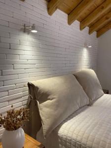 a bedroom with a bed with a white brick wall at Almyra in Propoúlion