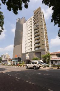 uma carrinha branca estacionada em frente a um edifício alto em Niwahas Apartment Borella em Colombo