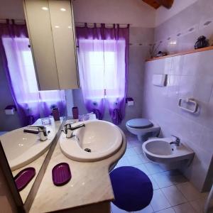 y baño con lavabo, aseo y espejo. en Villetta Arcobaleno - Your Mountain Holiday en Casargo