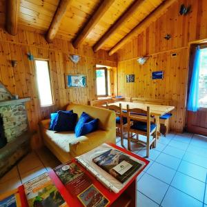 ein Wohnzimmer mit einem Sofa und einem Tisch in der Unterkunft Villetta Arcobaleno - Your Mountain Holiday in Casargo