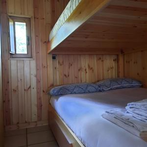 1 dormitorio con 1 cama en una cabaña de madera en Villetta Arcobaleno - Your Mountain Holiday en Casargo