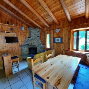 une salle à manger avec une table en bois et une cheminée dans l'établissement Villetta Arcobaleno - Your Mountain Holiday, à Casargo