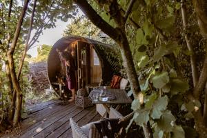 una terraza de madera con una mesa y una tienda en la cúpula en Vakantiewoning met sauna & hottub en zwempoel op Natuurterrein, en Heuvelland