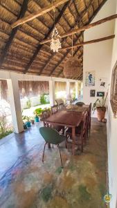 Kitesurf Tofo House في بارايا دو توفو: غرفة طعام مع طاولة وكراسي خشبية