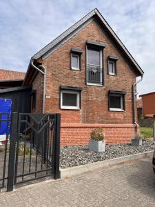 une maison en briques avec un portail en face de celle-ci dans l'établissement Dill Apartments Gadenstedt, à Ilsede