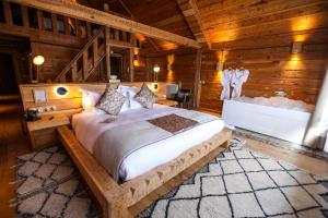 ein Schlafzimmer mit einem Bett in einem Holzzimmer in der Unterkunft Hotel Xaluca Spa Aguelmame Sidi Ali 