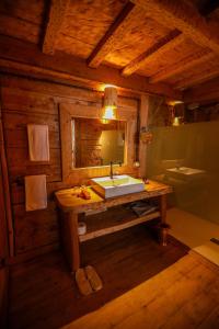 ein Bad mit einem Waschbecken und einem Spiegel in einer Kabine in der Unterkunft Hotel Xaluca Spa Aguelmame Sidi Ali 