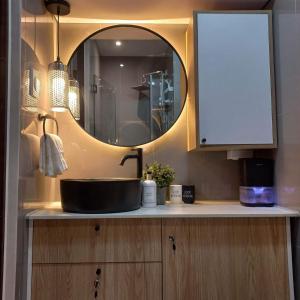 a bathroom counter with a sink and a mirror at Rustic industrial 1-BR condo with balcony at Air Residences Makati Manila in Manila