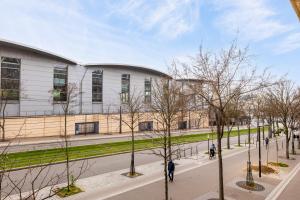 a building with trees in front of a street at Veeve - Vivid, Vivace in Paris