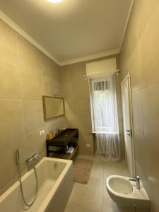 een badkamer met een bad, een wastafel en een bad bij Angolo di isa in Busto Arsizio