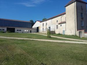 ein leeres Feld neben einem großen Gebäude in der Unterkunft Maison de la Vaux in Germonville