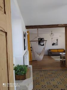 ein Wohnzimmer mit einer Hängematte und einer Couch in der Unterkunft Maison de la Vaux in Germonville