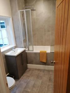 łazienka z wanną, umywalką i toaletą w obiekcie Halt Cottage w mieście Bridgnorth