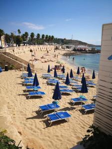 レウカにあるVilla Teresaの青いビーチチェアとパラソルのグループ