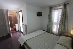 1 dormitorio con cama, ventana y baño en Villa Teresa en Leuca