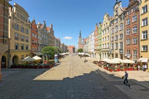 a street in a city with buildings and umbrellas at Apartament Długi Targ in Gdańsk