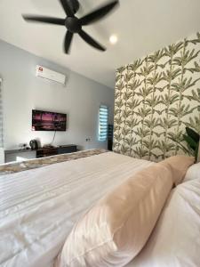 1 dormitorio con 1 cama blanca grande y ventilador de techo en Chantara Cottage, en Kampung Mawar