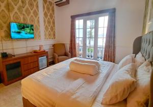 a bedroom with a bed and a tv on the wall at Gili Beachfront Suites in Gili Trawangan
