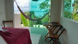 um quarto com uma mesa e uma janela com vista em Beija Flor em Gamboa