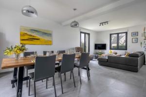 Un comedor con una mesa y sillas y un sofá. en 500m des plages - Vacances à 6 autour du Golfe, en Saint-Gildas-de-Rhuys