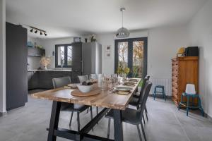 Una cocina y un comedor con mesa y sillas de madera. en 500m des plages - Vacances à 6 autour du Golfe, en Saint-Gildas-de-Rhuys