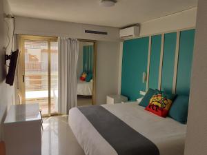 a bedroom with a large bed and a balcony at Hotel Clibomar Jamaica in Gandía