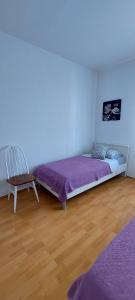 a bedroom with a purple bed and a chair at Apartman Alenka in Tkon
