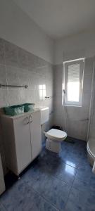 a bathroom with a toilet and a sink and a tub at Apartman Alenka in Tkon