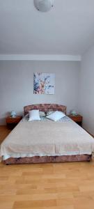 a bedroom with a large bed with two night stands at Apartman Alenka in Tkon