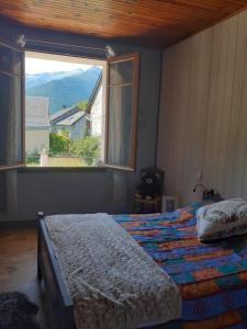 a bedroom with a bed and a large window at la maison blanche in Ustou