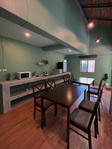 Una habitación con una mesa y sillas y una cocina. en Greenspace Living, en Ban Tha Phae