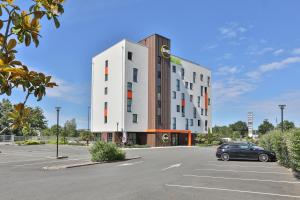 a building with a car parked in a parking lot at B&B HOTEL La Roche-sur-Yon in Mouilleron-le-Captif