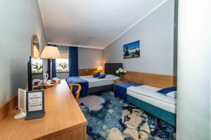 ウォムジャにあるMetropolのベッド2台とデスクが備わるホテルルームです。