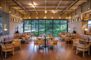 a restaurant with tables and chairs and a large window at The RuMa Hotel and Residences in Kuala Lumpur
