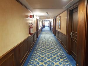 um corredor de um hotel com piso em azulejo azul e branco em Santa Barbara Hotel em San Donato Milanese