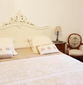Villa Les Palmiers في ويميريوكس: سرير أبيض مع اللوح الأمامي الأبيض ووسادتين