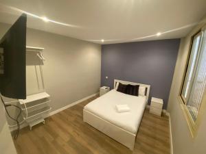 a bedroom with a white bed and a television at Apartamentos Sol Madrid in Madrid
