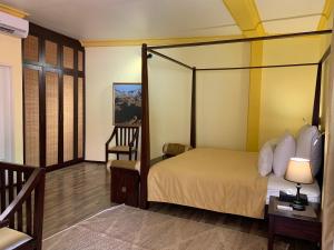 a bedroom with a canopy bed and a chair at Sala Boutique Hotel in Male City