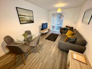 a living room with a couch and a glass table at Halo Apartments - City Centre in Manchester