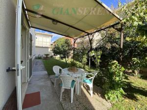 um pátio com uma mesa e cadeiras sob um dossel em Costa - trilocale con giardino em San Vincenzo