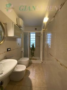 uma casa de banho com 2 WC, um lavatório e um chuveiro em Costa - trilocale con giardino em San Vincenzo