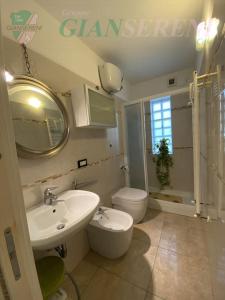 uma casa de banho com um lavatório, um WC e um espelho. em Costa - trilocale con giardino em San Vincenzo